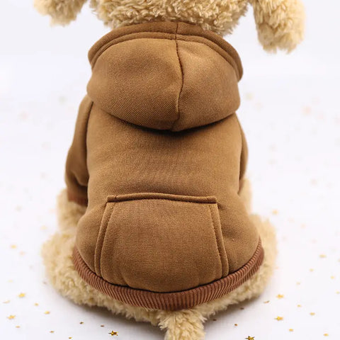 Dog wearing a brown fleece coat with a hood on white background.