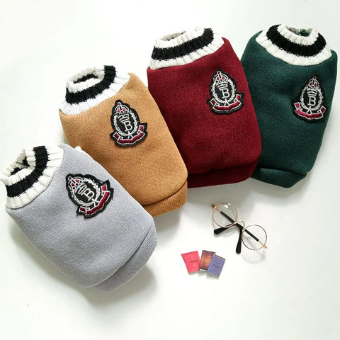 Five dog sweaters in different colors with a logo on white.