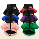 Four colorful dog coats with The North Face logo on light blue.