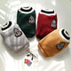 Four dog sweaters in gray, green, red, and brown with a logo on a white surface.