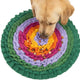 Overhead view of a Golden Retriever sniffing kibble hidden inside a rainbow circular slow feeder snuffle mat.
