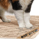 Close-up of cat paws stepping onto a beige Gorilla Grip cushioned litter trapping mat