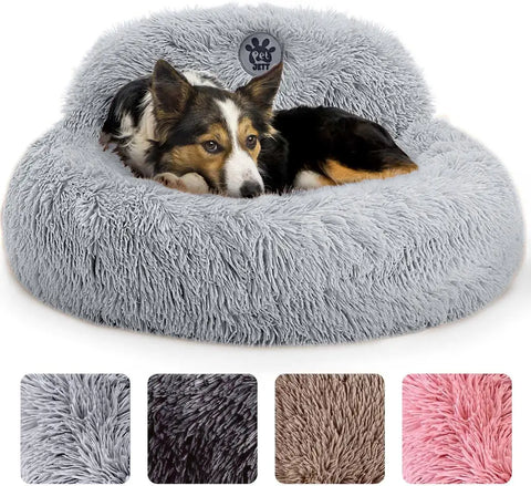 Medium dog lying in a light gray plush round donut bed with head support