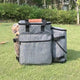 Gray pet carrier with a dog inside on grass.