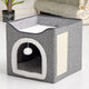 Gray pet house with white interior and a hanging ball on wooden floor.