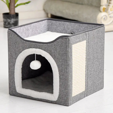 Gray pet house with white interior and a hanging ball on wooden floor.