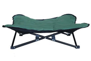 Green dog camping cot with a durable black frame for elevated and breathable rest