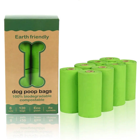 Green dog poop bags with Earth friendly packaging on white.