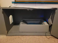 Customer photo showing the PetSafe ScoopFree automatic litter box neatly tucked inside a grey cat furniture enclosure.