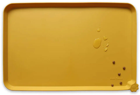 Honey warm golden brown silicone pet feeding mat with water droplets and kibble.