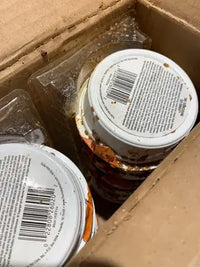Customer feedback photo showing a cardboard shipping box of Merrick Lil Plates wet dog food cups with visible barcodes.