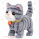 Grey and white striped tabby cat electronic plush toy with an orange collar and bell