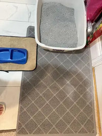 Extended grey diamond-mesh litter trapping mat laid on tile floor beside a plastic cat litter box