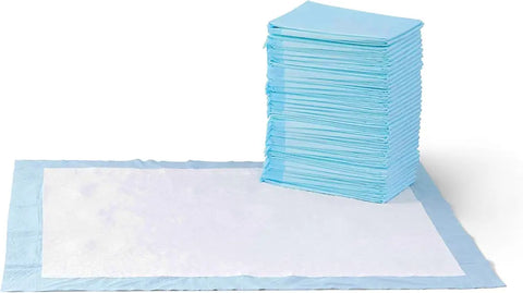Tall stack of folded blue pet potty pads sitting next to a flat open absorbent training mat