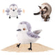 Male sandpiper chirping and flapping bird cat toy on sand with a curious Siamese cat in the background