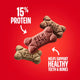 Close-up of three different flavored Milk-Bone Mini treats highlighting 15% protein and healthy teeth support.