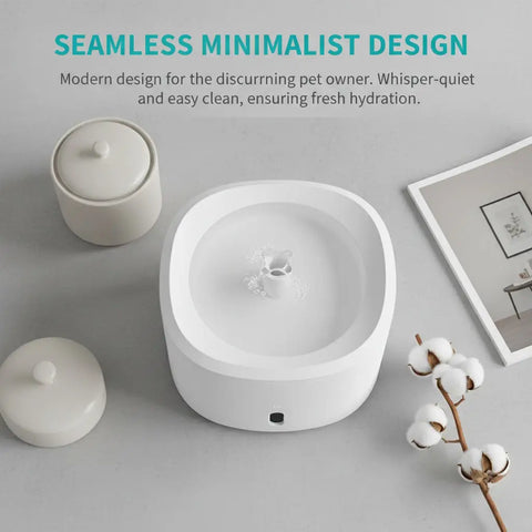 Top-down view of a modern, seamless, minimalist white cat water fountain on a counter.