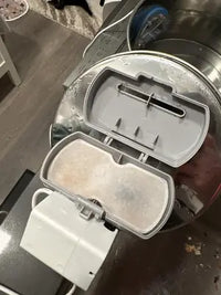 Customer review photo of white contoured replacement carbon filters stacked on top of their blue retail packaging box.