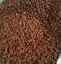 Close-up customer review photo showing the realistic texture and brown color of the square-shaped grain-free dog food kibble pieces.