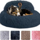 Small dog resting in a navy blue plush calming donut bed with raised backrest
