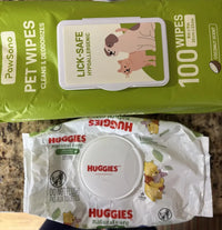 Customer review comparison showing green PawSono plant-based pet wipes alongside white Huggies Natural Care baby wipes on granite countertop