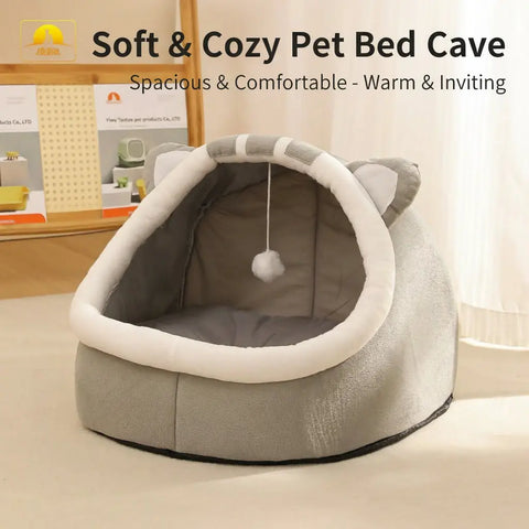 Pet bed with cat ears on a beige surface with blurred background.