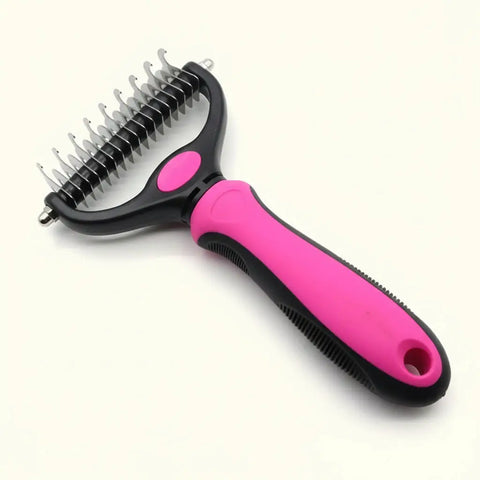 Pet grooming brush with pink handle and black bristles with text.