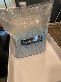 Customer image of a fresh bag of PetSafe blue crystal cat litter being prepared for a replacement tray.