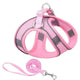 Pink and gray dog harness and leash set on white background.