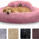 Golden retriever sleeping peacefully in a large plush pink calming donut dog bed