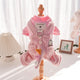 Pink dog sweater on mannequin against white curtain background.