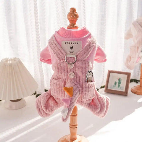 Pink dog sweater on mannequin against white curtain background.