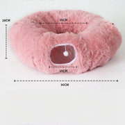 Pink donut-shaped pet bed with detailed measurements and raised plush rim for support