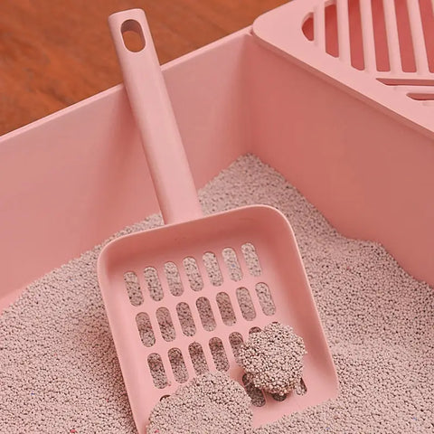 Pink litter scoop with ergonomic handle and fine mesh for clump removal.