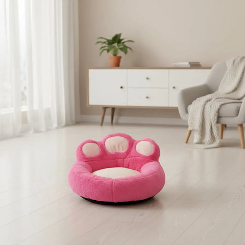 Pink paw-shaped pet bed on white background view.
