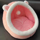 Pink pet bed with white trim on a dark surface.