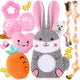 A cute assortment of pink puppy toys featuring a large grey bunny plush, a pink smiling heart, a carrot toy, pink teething rings, a treat ball, rope toys, and pink poop bags.