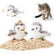 Pair of female and male sandpiper interactive flapping bird cat toys sitting on sand with a kitten looking on