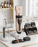 professional cordless dog grooming clipper kit in champagne gold and black on a high-end white marble vanity, including 6 guard combs, grooming scissors, dual-spacing steel comb, power adapter, and cleaning accessories.