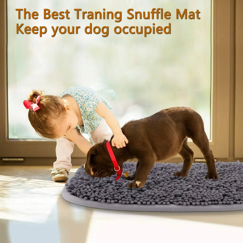 A young child playing with a brown puppy searching for food on a grey interactive training snuffle mat