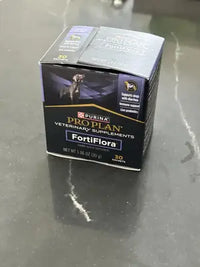 A box of Purina Pro Plan Veterinary Supplements FortiFlora canine probiotic supplement for dogs sitting on a dark grey countertop.