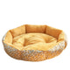 Round pet bed with yellow interior and patterned exterior.