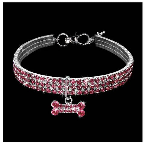 Silver dog collar with pink gemstones and bone-shaped charm.