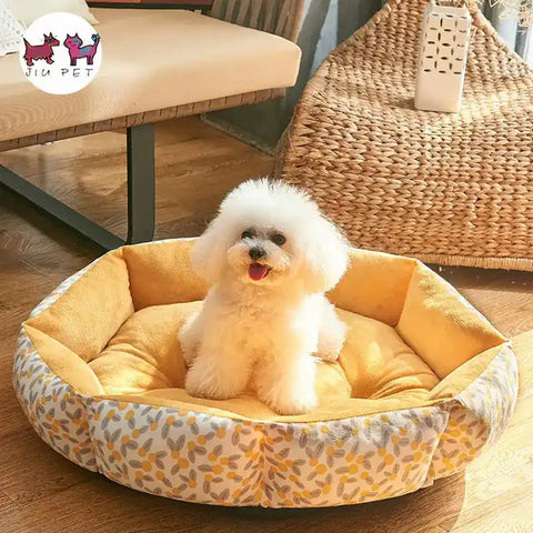 Small white dog sitting on yellow pet bed with wicker chair.