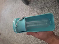 Customer review photo showing a hand holding a lake blue folded Soicta dog water dispenser