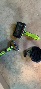 Close-up profile of the SWIHAUK pet brush highlighting the textured non-slip thumb grip and blue ergonomic handle.