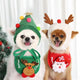 Two dogs wearing Christmas-themed outfits with tree hat and antlers.