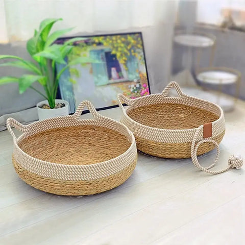 Two woven baskets on table with plant and picture frame.