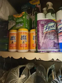Canisters of Wet Ones for Pets antibacterial multi-purpose wipes stored alongside household cleaning products in a customer's pantry.