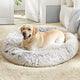 Golden Retriever resting comfortably on a white grey plush donut dog bed